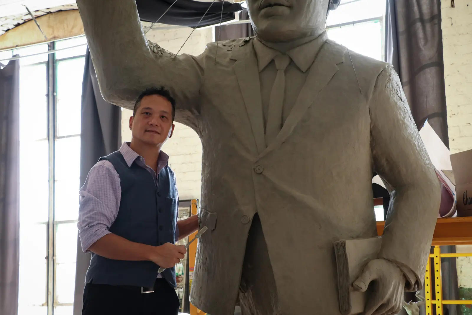 Andrew Luy beside the full-scale clay figure for The Ripple